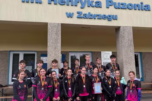 Drużyna sportowców z medalami przed Stadionem im. H. Puzonia w Zabrzegu. Fotografia.