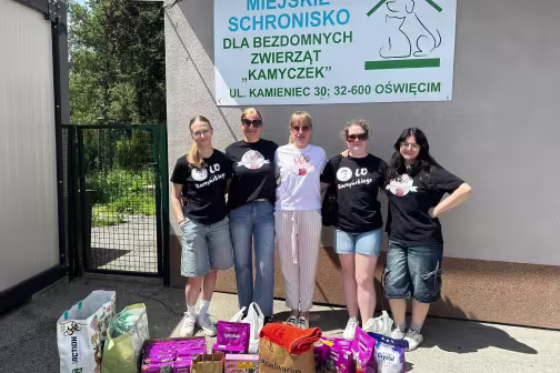 Pięć kobiet z darowizną karmy dla zwierząt przed schroniskiem "Kamyczek".